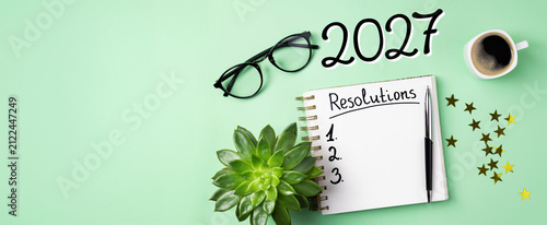 New year resolutions 2027 on desk. 2027 resolutions list with notebook, coffee cup on table. Goals, resolutions, plan, action, checklist concept. New Year 2027 template, copy space