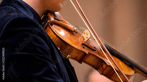 Musician playing violin with focused expression in close-up shot