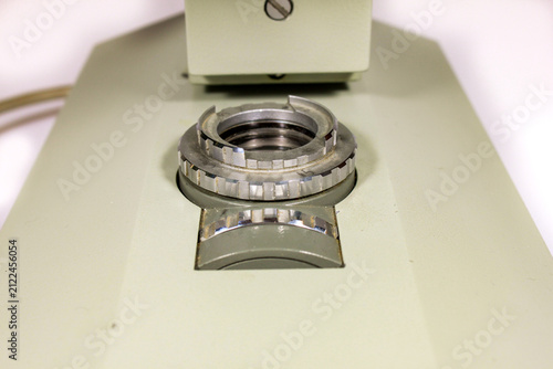 Fotografie Close-up of a microscope light source and illuminator on a vintage laboratory microscope isolated on a white background