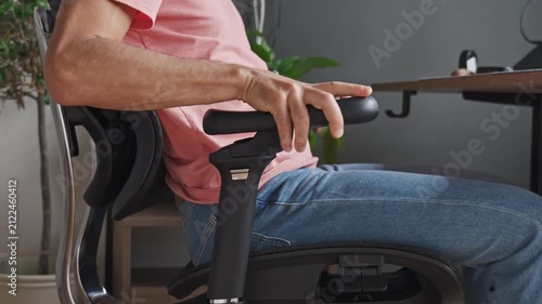 Man Adjusting Armrest on Ergonomic Office Chair