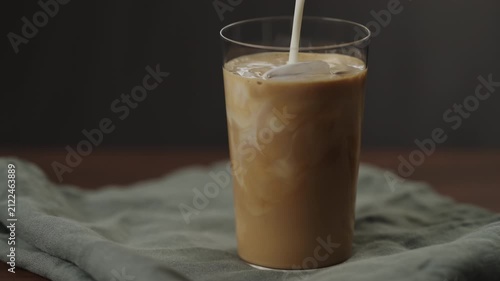 Slow motion making ice latte at home closeup shot