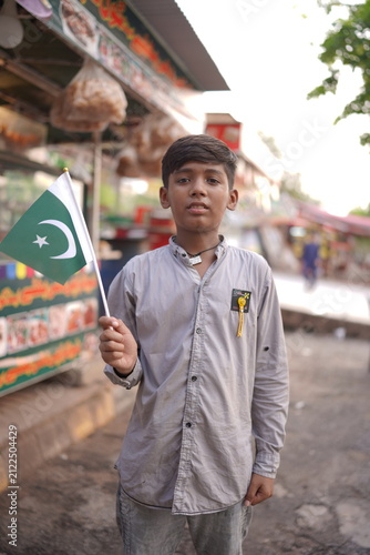 Foto Pakistani Kid with National Flag in Street for Independence Day Festivities