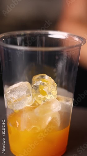 A professional bartender preparing delicious beverages in a modern café. Mixing drinks, creating cocktails and serving guests in a stylish restaurant atmosphere.