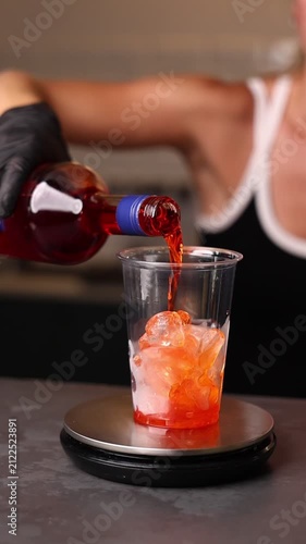 A professional bartender preparing delicious beverages in a modern café. Mixing drinks, creating cocktails and serving guests in a stylish restaurant atmosphere.