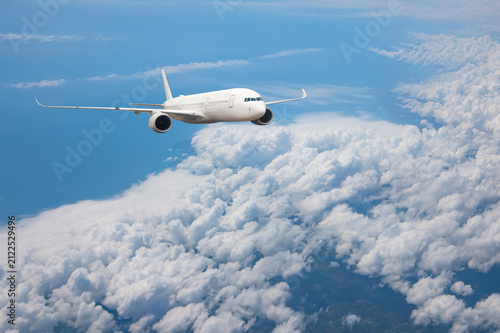 White passenger airplane flying in the sky amazing clouds in the background - Travel by air transport
