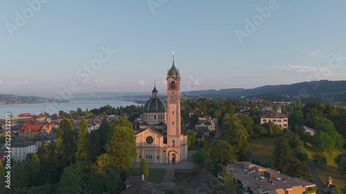 Aerial Drone Orbit Around Reformierte Kirche Enge Church Tower at Sunset Over Zurich and Lake Zurich, Switzerland (ProRes)