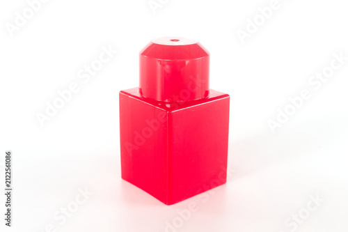 Red plastic building block toy on white background