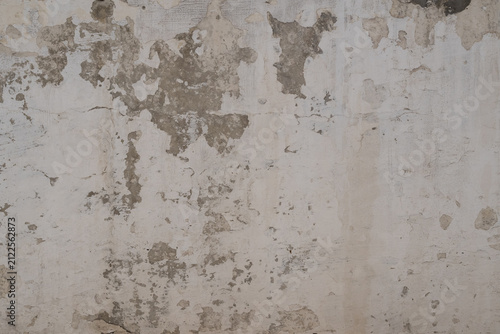 Old distressed wall with cracked plaster and peeling paint creating a realistic grunge texture. Ideal background for design, architecture and creative projects.