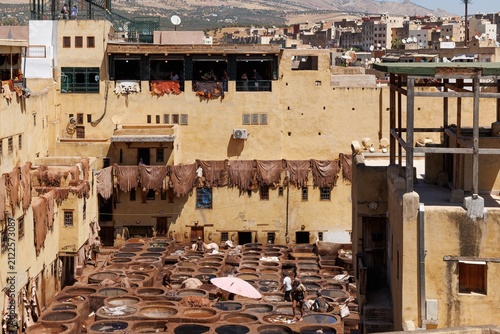 Fotografía An elevated view of the historic Chouara Tannery in the Fez medina, showing rows of colorful stone dye pits and workers treating leather hides by hand