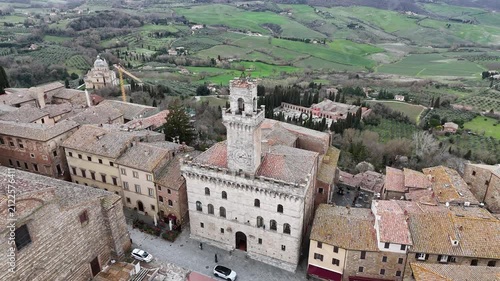 Cinematic drone 360 degree orbit shot circling the historic Comune di Montepulciano town hall in Tuscany Italy
