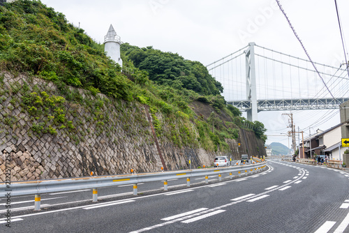 Coastal road with stone retaining wall and Kanmon Bridge view