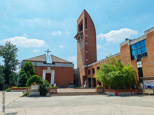 Wide view of the red brick Catholic church and bell tower of Beijing Catholic Theological Seminary in summer in Houbajia, Beijing, China