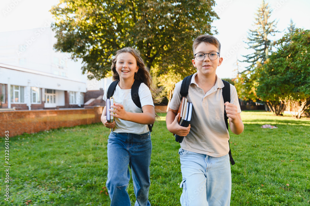 Obraz premium Schoolchildren running happy to class on campus