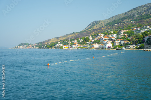 Foto Coastal town with white buildings on a hillside above the blue Adriatic Sea