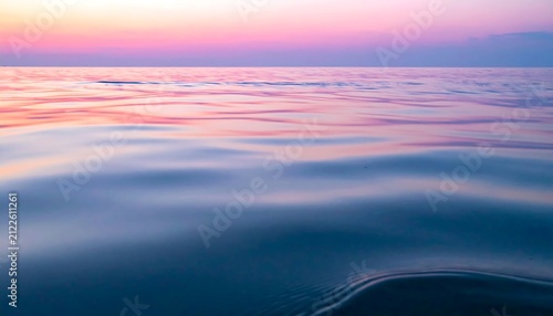 Calm ocean water surface reflecting vibrant pink and purple sunset sky for World Maritime Day peaceful background