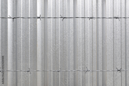 Canvastavla horizontal two barbed wire stretched in front of silver corrugated metal sheet f