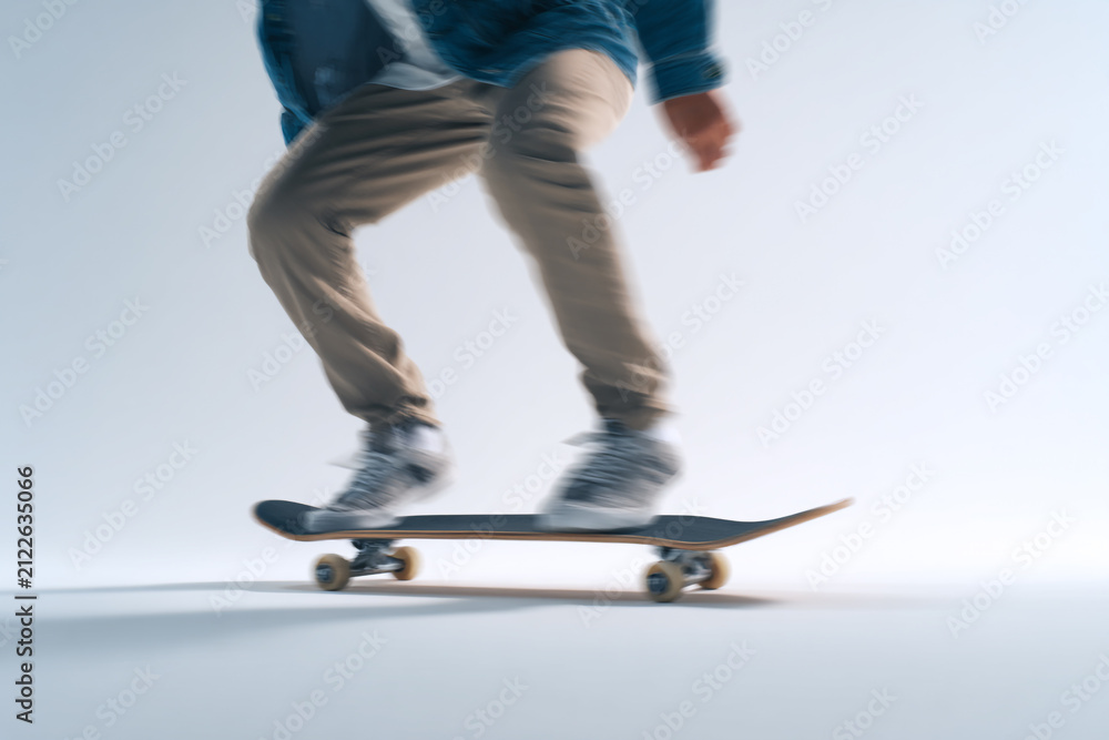 Naklejka premium Skateboarder in motion blur captured in dynamic studio photography, isolated on clean white background with cinematic photorealistic quality. 