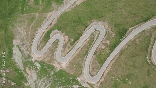 Aerial view of a car and motorcycle passing on the winding Transalpina mountain road in Romania