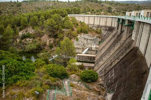 View of Beniarres dam wall with staircases and water flowing into Serpis River in Spain