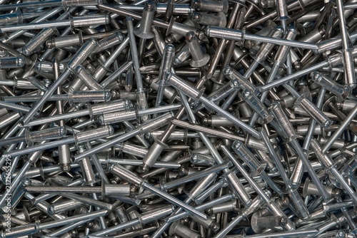 Blind Pop Rivets scattered background metal fasteners building hardware.