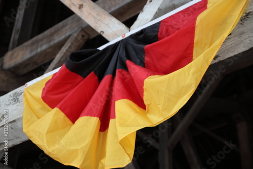Crowd enjoying Oktoberfest celebration inside a decorated festival hall with German flags and live music