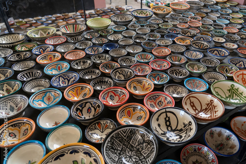 A vast array of handcrafted Moroccan ceramic bowls and plates displayed and ready for sale at a store in Morocco.