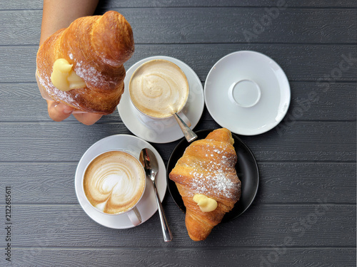 woman making breakfast with croissant and cappuccino