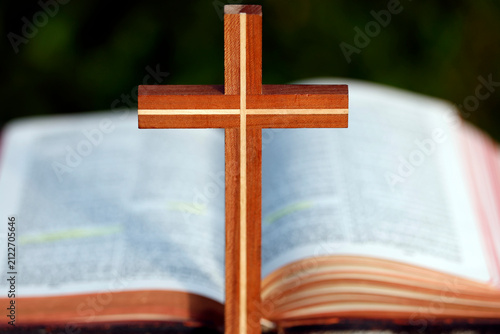 Quadro su tela Faith and devotion symbolized by a hand-carved wooden cross placed in front of an open Bible