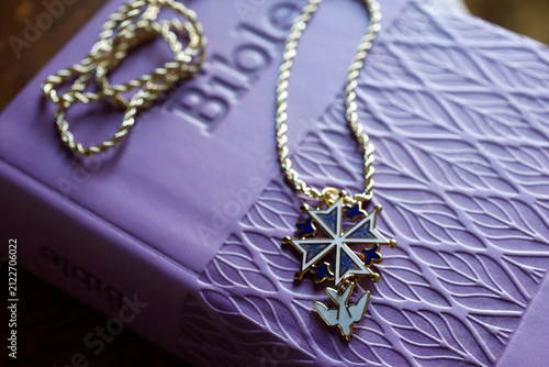 Принти на полотні A Protestant Huguenot cross in blue enamel, adorned with a white dove, resting on a Bible