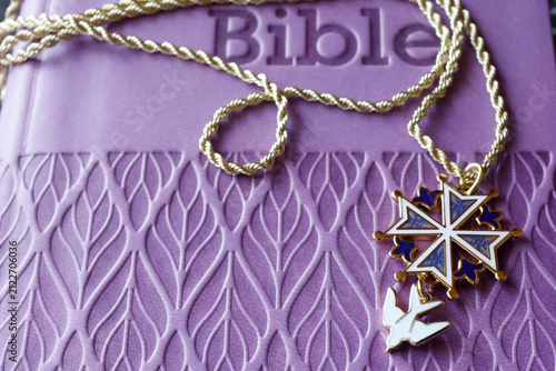 Konstfotografi A Protestant Huguenot cross in blue enamel, adorned with a white dove, resting on a Bible