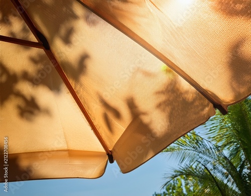 leaf shadows dancing on sunlit umbrella surface for summer vacation mood patio cafe ambience outdoor leisure heatwave season content staycation themes and summer peaceful backdrops