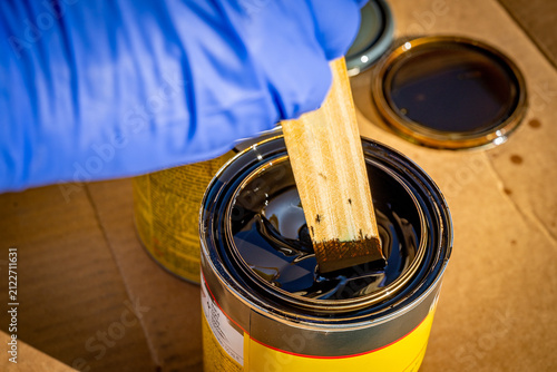 Obraz na plátne Wooden stick used to stir dark stain before use