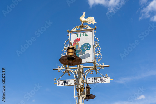 Vintage Roadsign With Rooster Emblem Pointing to Chessam Epsom Chislehurst And Croydon Under Blue Sky