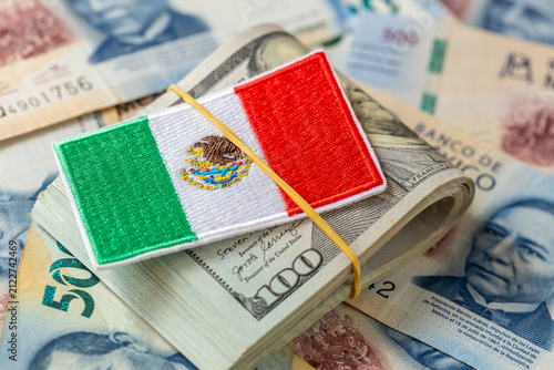 US dollar vs. Mexican peso. Stack of dollars with the Mexican symbol. Business and finance concept. Currency exchange. Money transfers, cross-border trade, customs duties, and taxes.