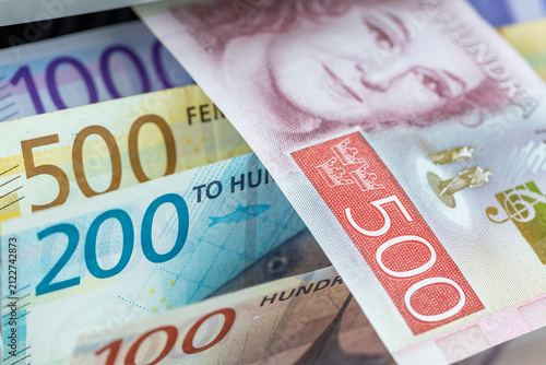 Fotografie Swedish Krona versus Norwegian Krone banknotes inside currency counter machine