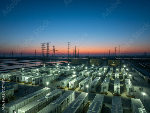 Energy storage power station with container arrays illuminated at dusk under twilight sky