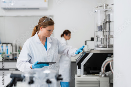 Quadro su tela Expert scientist using digital tablet to operate advanced laboratory machine for chemical extraction