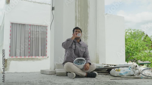 Home inspector sitting construction site, holding helmet, checking new building exterior, standing near white house interior renovation, drinking water and resting floor, sitting thoughtful beside