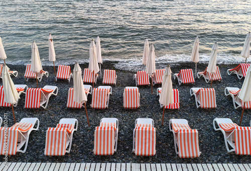 Fotografía Evening beach with sun loungers and umbrellas against the backdrop of the sea in