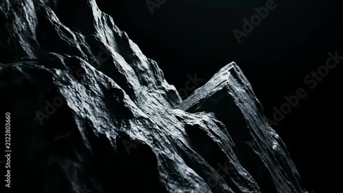 Slow camera pan across jagged dark rock formations against a black background. Dramatic lighting highlights textures of stone peaks. Concept of geology, minimalism, cinematic background, abstract