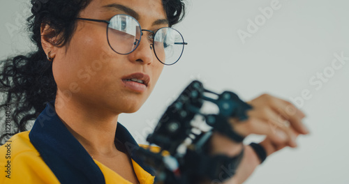 Close-up young Black female engineer coding AI robot arm in modern laboratory. Robotics, artificial intelligence, technology, stem, future, innovation, diversity, automation, machine learning concept.