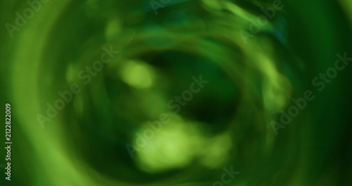 Bokeh light. Green glitter texture. Vibrant natural color lens flare bright optical glisten reflection on abstract illuminated black background.