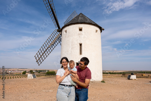 Family smiling with baby at traditional windmill in Tembleque, Toledo