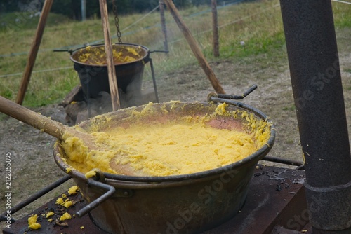 Paiolo o pentola  di rame fumante di polenta  con mestolo in legno