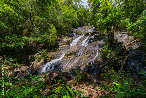 Tropical mountain scenery featuring the iconic Ngao Waterfall, one of Ranong's best-known natural landmarks, attracting visitors with its impressive cascade and lush national park environment.