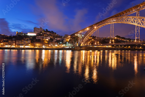 Colorful view of sunset at the Ponte D. Luis Bridge with lights reflecting in the Douro River in Porto, Portugal