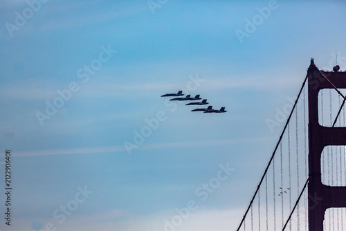 Blue Angels fly past the Golden Gate Bridge during a daytime airshow.