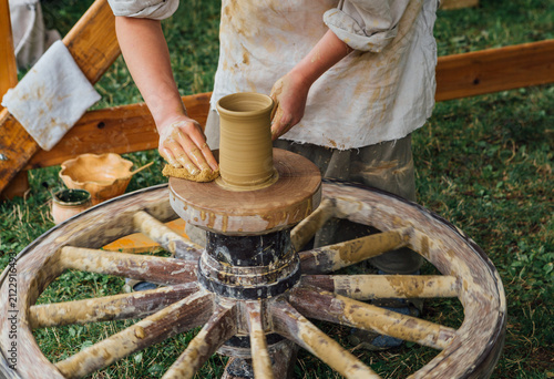 Artisan Potter Shaping Clay Mug On Traditional Manual Pottery Wheel Historical Reenactment Craftsmanship Skill Workshop Ancient Pottery Making Process Outdoors Fair
