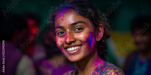 Smiling Young Woman Celebrates Holi Festival with Vibrant Colors on Face