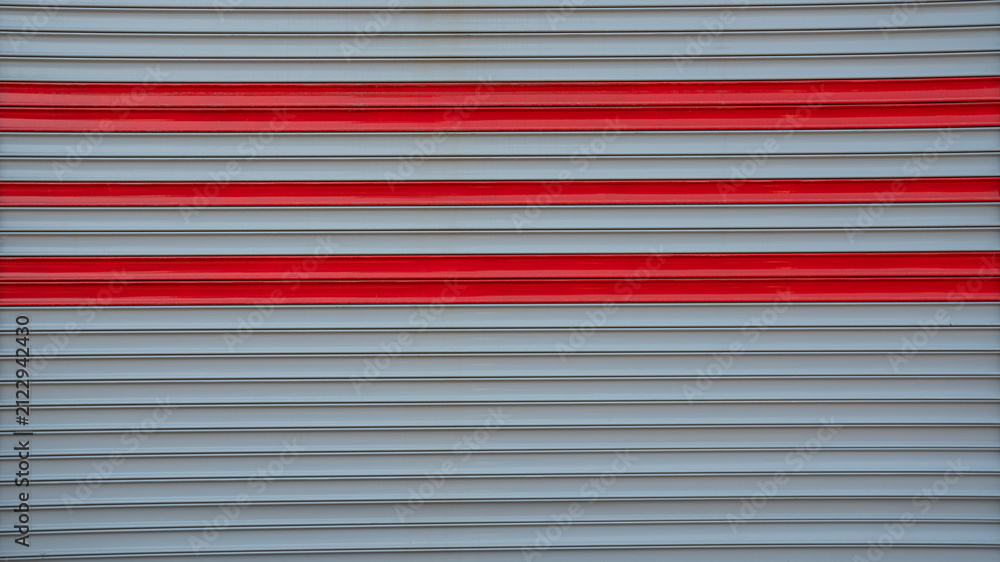 Naklejka premium Metal Roller Shutter Door Texture Background with Red Horizontal Accent Lines